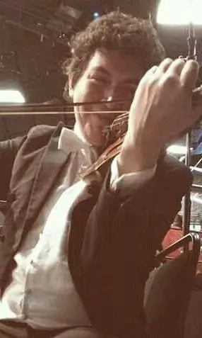 Violinista Edwin Díaz tocando durante un concierto con el Ensamble Dalí de Alfamusic, vestido de frack