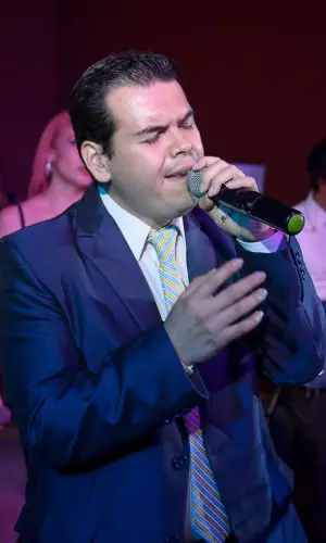 Cantante Emanuel Santiago en el escenario durante una presentación del grupo versátil Alfamusic