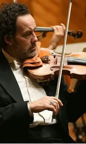 Violinista Giulio Angelini vestido de frack durante un concierto de la orquesta sinfónica
