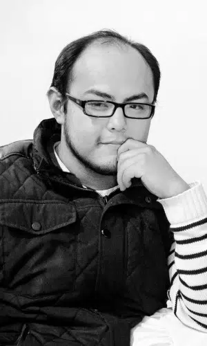 Ingieniero de audio e iluminación Daniel en foto a blanco y negro en posición meditativa