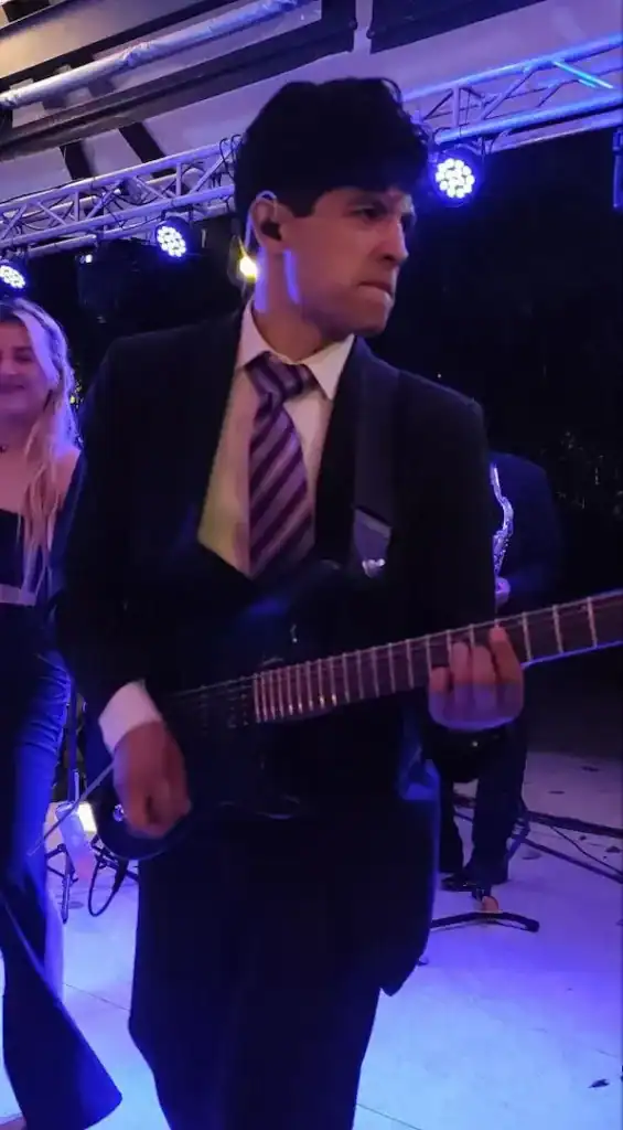 Joven músico tocando guitarra en boda de Pamela y Jacob.