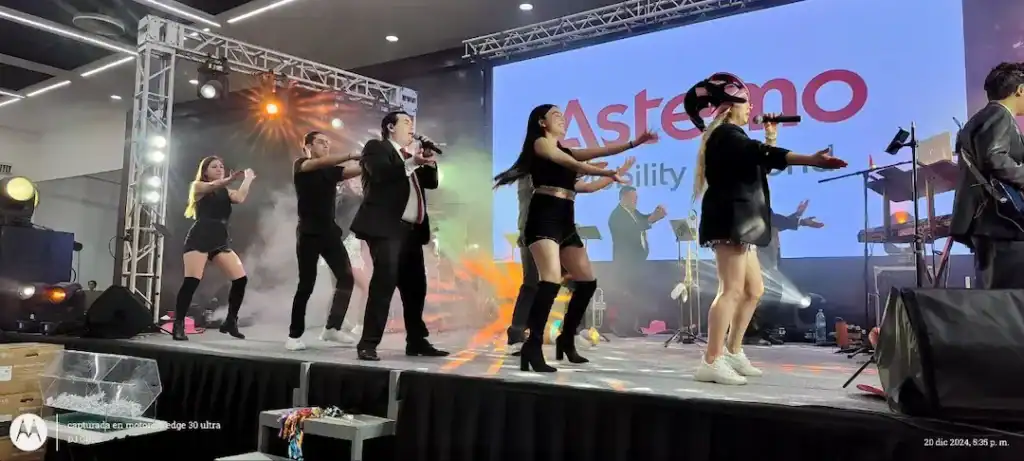 Participantes bailando en evento de fin de año Astemo en el escenario.