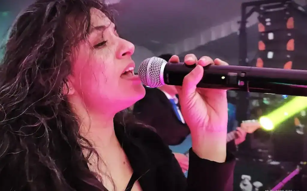Mujer cantando en vivo en celebración de XV años de Ana Paula.