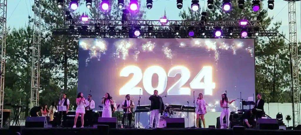 Escenario en la Feria de Metepec 2024 con artistas en vivo y luces vibrantes.