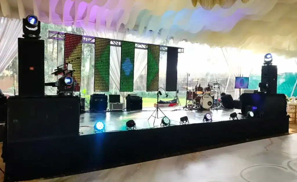 Escenario de boda con equipo de sonido y iluminación para evento en vivo.