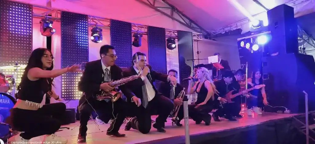 Grupo musical Alfamusic en evento de XV años de Camila, tocando en vivo con instrumentos y energía.