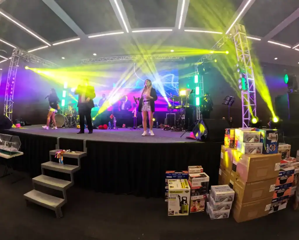 Escenario con iluminación vibrante y música en vivo en evento corporativo.
